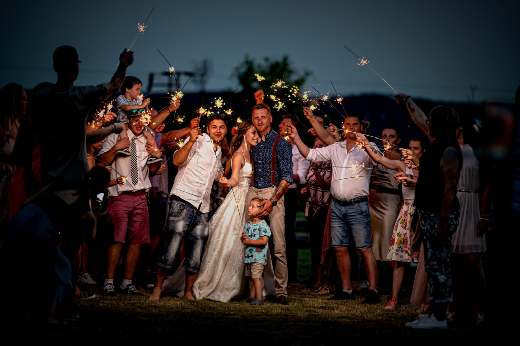 Svatební hosté s prskavkami v noci - wedding crowd with sparklers at night